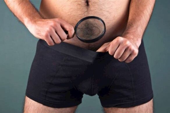 muž s lupou skúma svoj penis a chce ho zahustiť